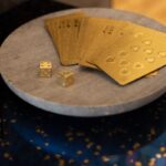 gold cards and two dices on round wooden platform