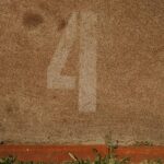 Close-up view of lane number four on an athletics track with visible texture.