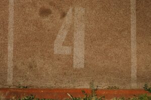 Close-up view of lane number four on an athletics track with visible texture.