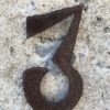 a close up of a number three on a rock