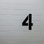 black arrow sign on white brick wall