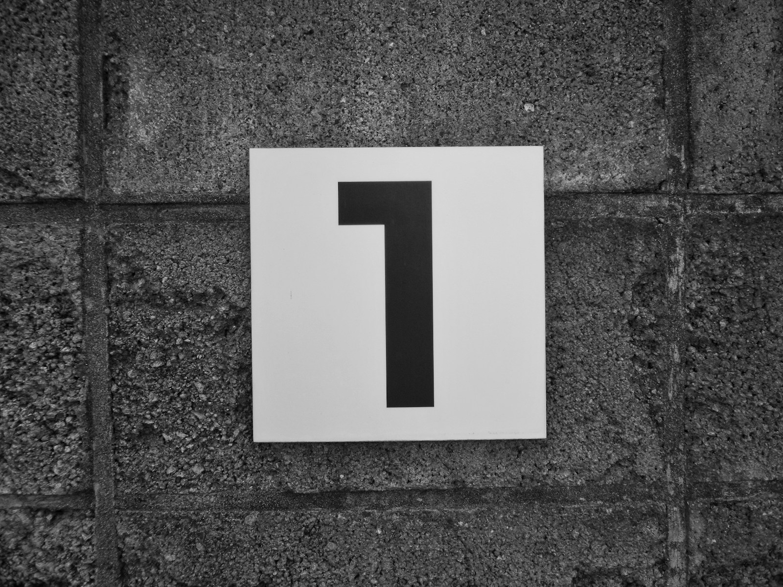 a black and white photo of a sign on a wall