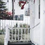 Front view of a house with vibrant red number 7 and white wooden railing.