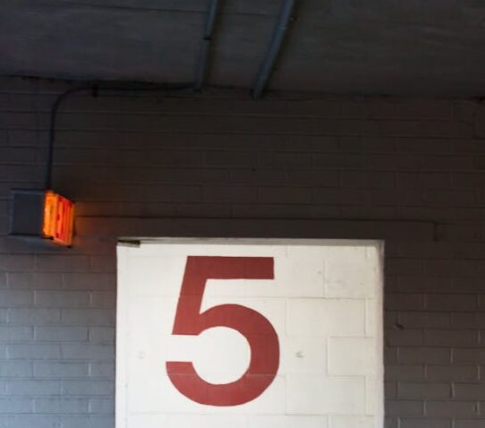 Entrance to a parking garage level with signage and door.