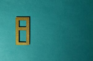 Golden number eight cutout on a teal background, perfect for decorative purposes.