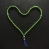 green beaded necklace on black textile