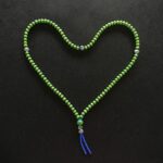 green beaded necklace on black textile