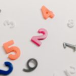 Colorful plastic numbers scattered on a white surface, great for educational themes.