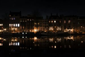 lighted building near body of water during night time